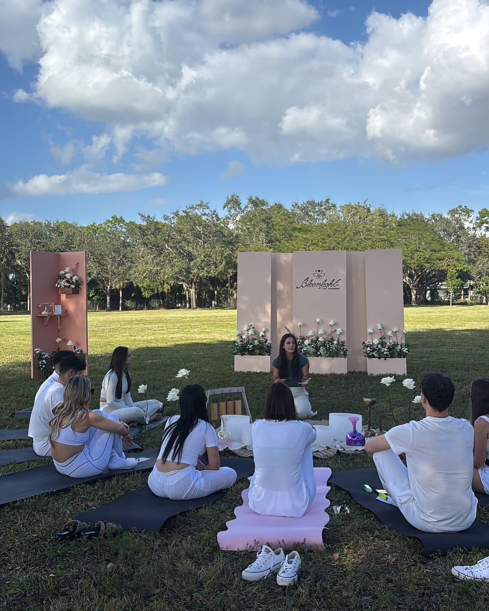 Guests sitting in a circle at a Bloomlight gathering in a park