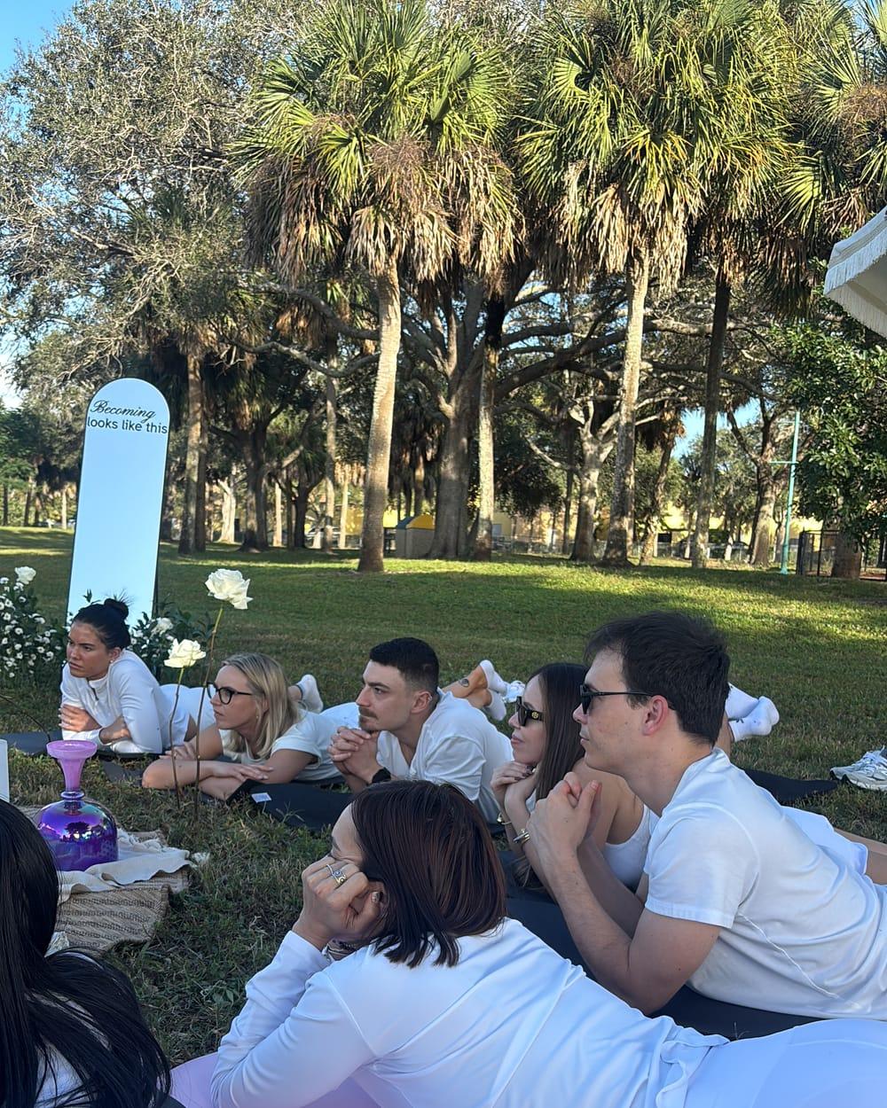 Guests sitting in a circle at a Bloomlight gathering in a park